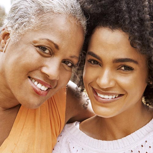 A middle-aged woman and her daughter smiling