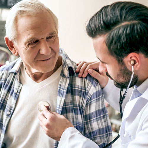 A male doctor uses a stethoscope to listen to a man