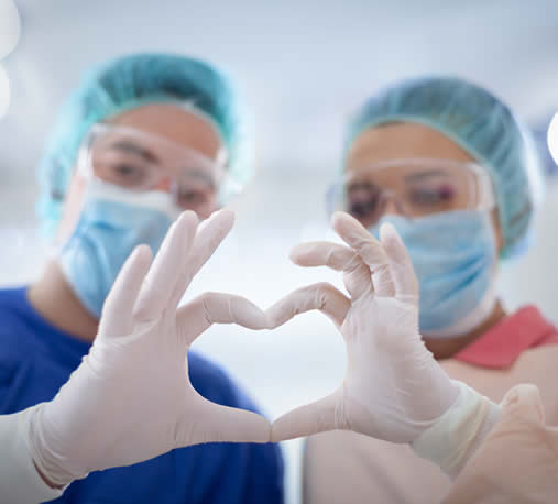 Surgeons making their hands into a heart shape.