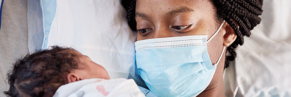 Nueva mamá mirando a los ojos de su bebé recién nacido